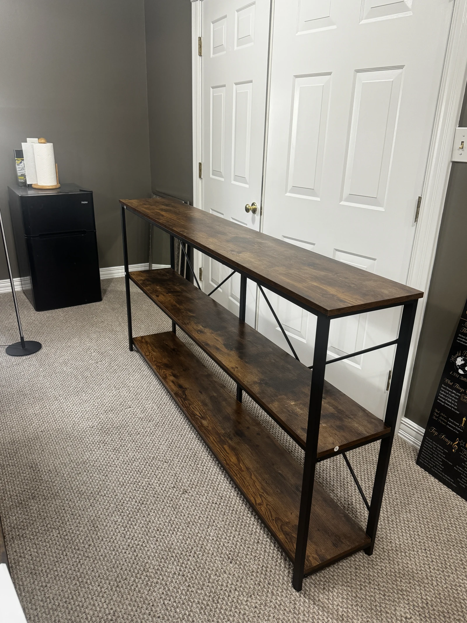 Assembled narrow console table with a wood top and dark metal frame