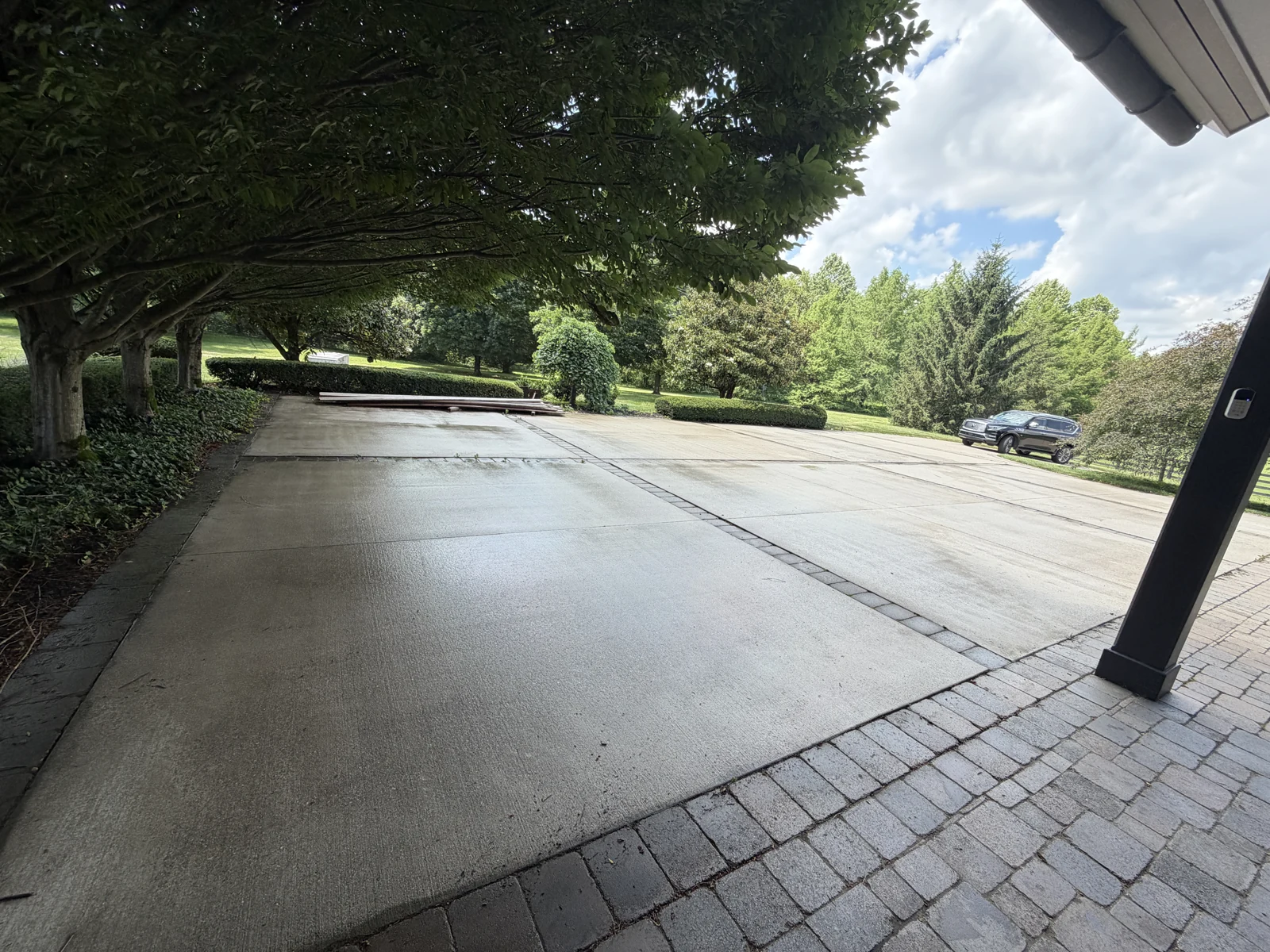 Wet concrete driveway and paver borders during a cleaning visit