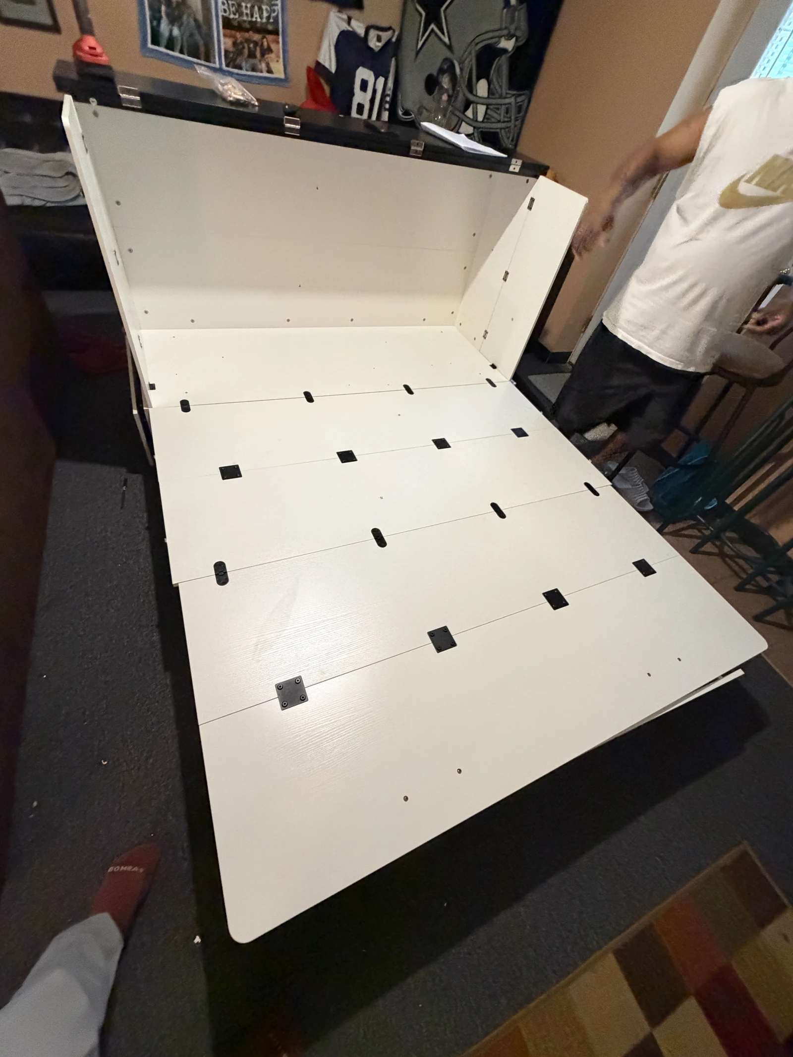White folding platform extended from a cabinet during assembly
