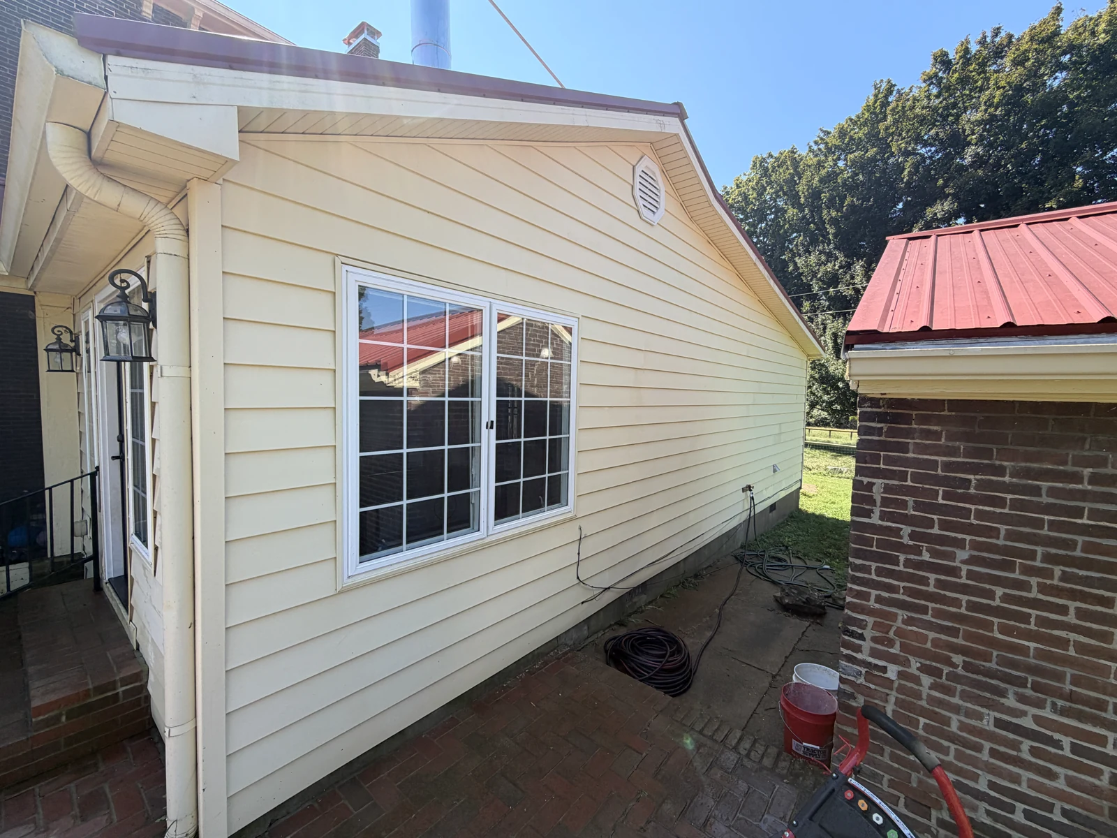 Cleaned yellow siding around the courtyard window after washing
