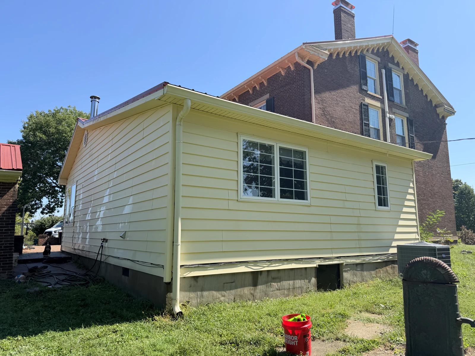Cleaned yellow gable and side wall with existing paint wear still visible