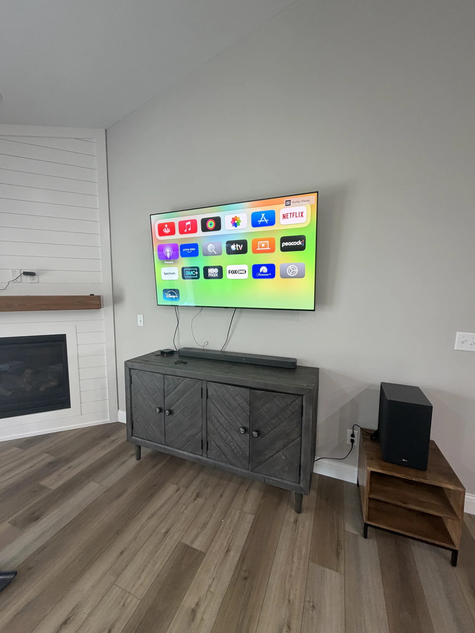 Wall-mounted television above a gray media console in a living room