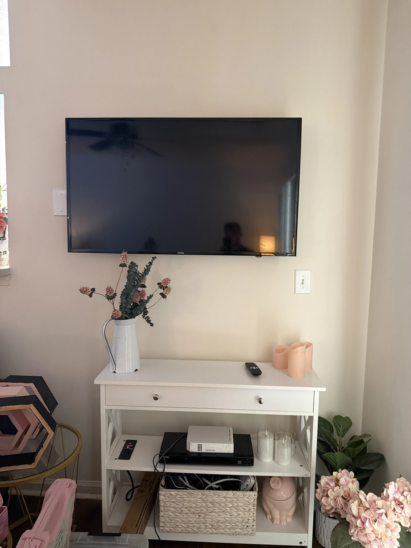Wall-mounted television above a white media console