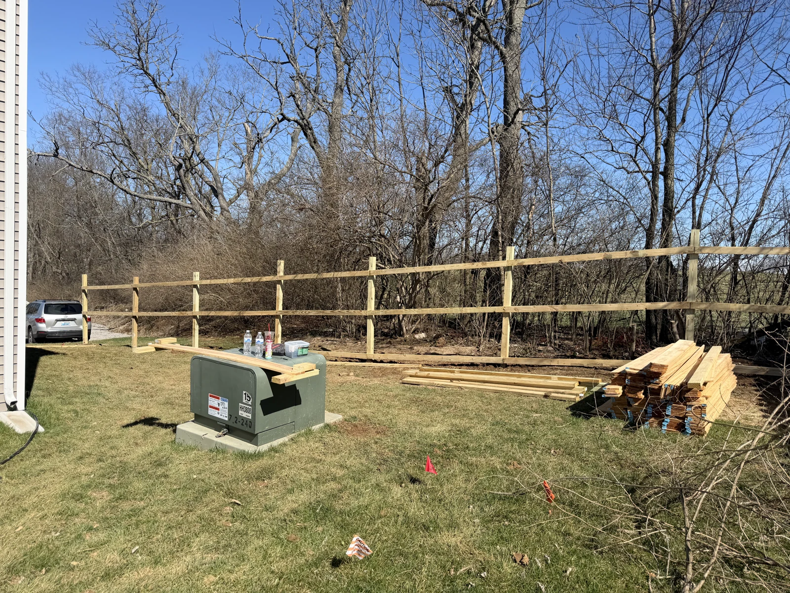 Wood posts and rails during a residential fence installation