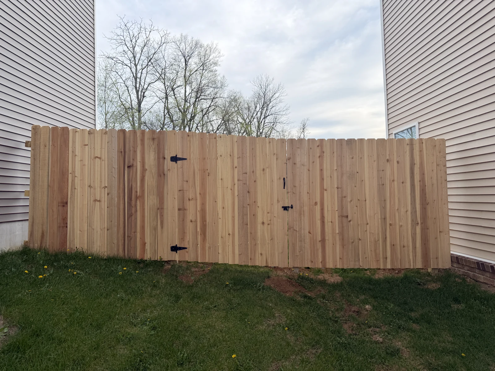 Finished wood privacy fence with a gate between two homes