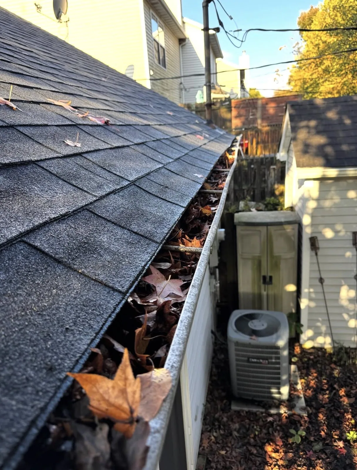 Leaves and debris filling a residential gutter before cleaning in Lexington Kentucky