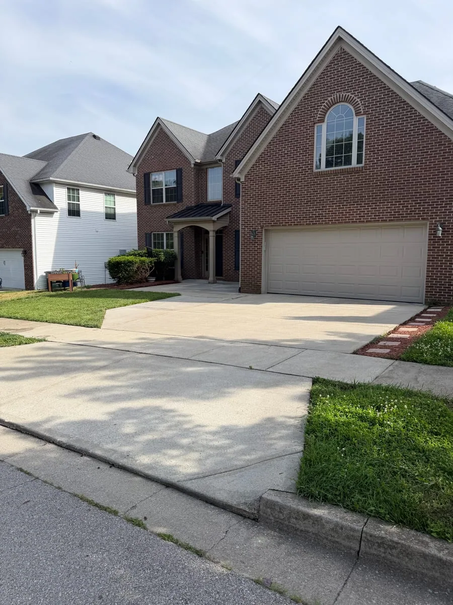Lexington brick home and concrete driveway after exterior cleaning by Arorix Home Solutions