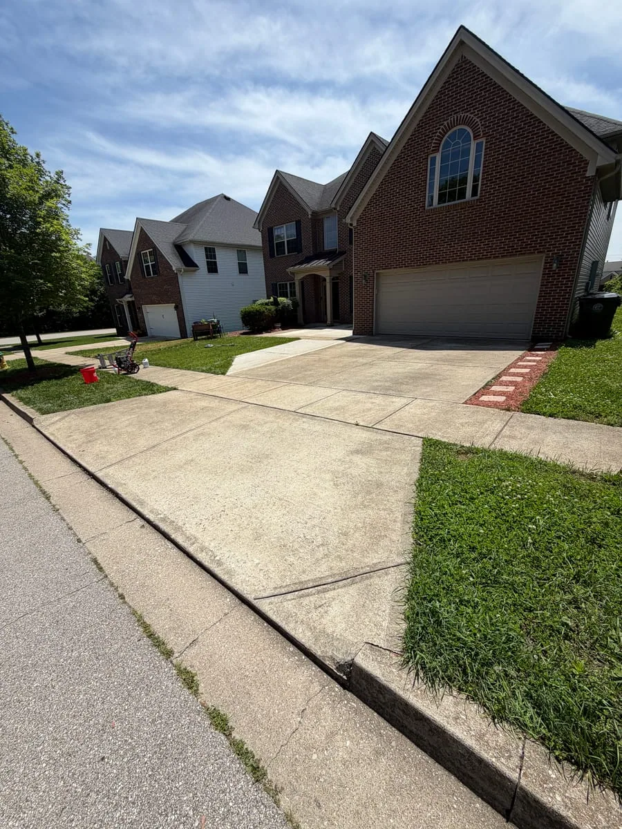 Lexington brick home and concrete driveway before exterior cleaning by Arorix Home Solutions