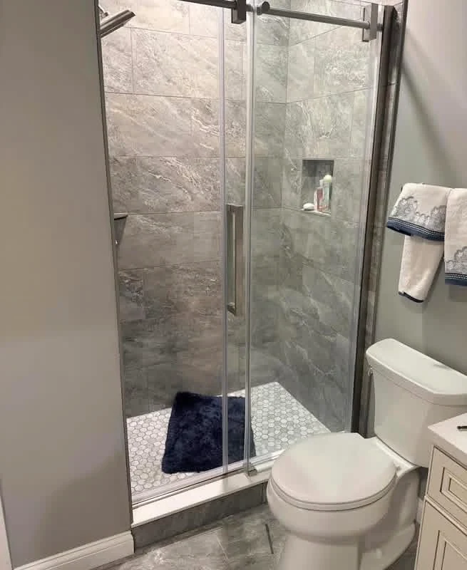 Glass shower door installed at a tiled shower opening